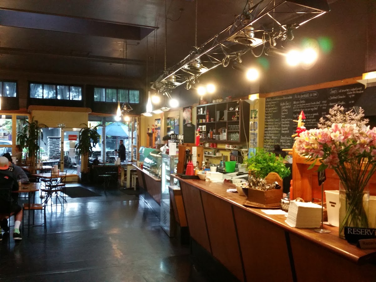 Inside Whispers Cafe, the counter, fresh flowers and the blackboard menu