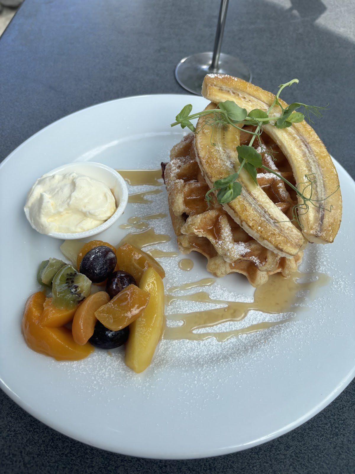 Banana waffles with fresh fruit, cream and maple